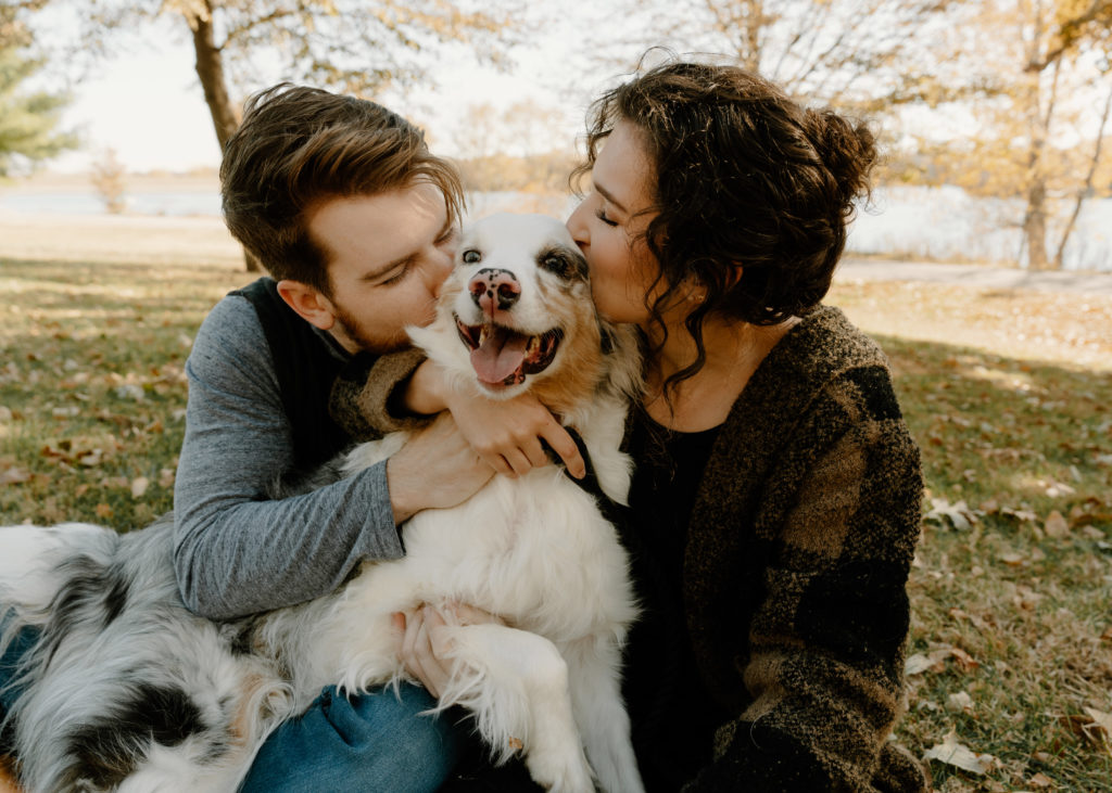 Omaha fall engagement session with dog at standing bear lake, couple kissing their dog.