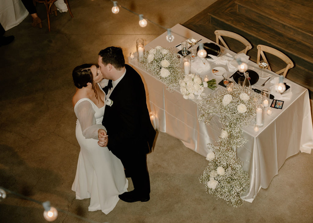 Photo of bride and groom kissing during first dance at reception. Choosing your wedding photographer is important.