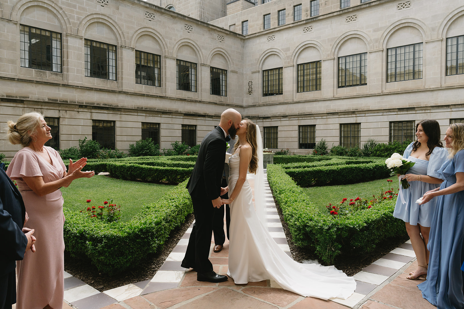 Intimate family ceremony in the courtyard garden of the Nebraska State Capitol, officiated by the groom's father — photographed by Britt McNeil Photography